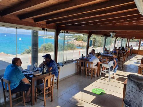 a group of people sitting at tables in a restaurant at Akkum Beach Otel in Seferihisar