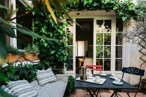 un patio avec une table, des chaises et une fenêtre dans l'établissement Magnifique maison de ville, La Rochelle, à La Rochelle