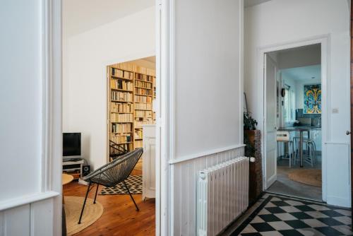 Cette chambre dispose d'un couloir avec une chaise et une bibliothèque. dans l'établissement Magnifique maison de ville, La Rochelle, à La Rochelle