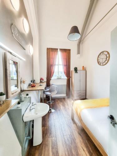 a bedroom with a bed and a sink and a desk at CADeS accommodation in Wolverhampton