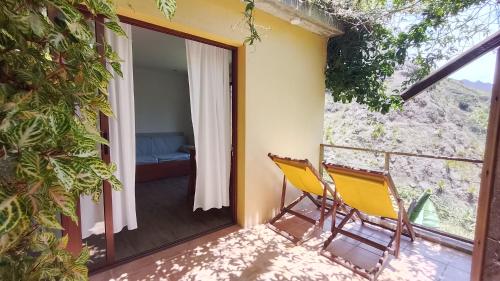 a pair of chairs on the balcony of a house at Casa Cavoquinho in Paul