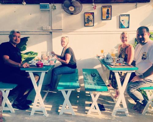 a group of people sitting at tables in a restaurant at Double Mango Villa in Katunayake
