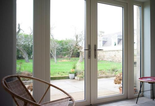 una porta scorrevole in vetro con vista su un cortile di The Presbytery, Forres a Forres