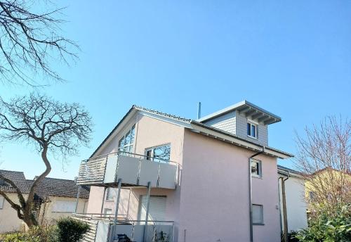 a white house with a balcony on top of it at Ferienwohnung Anna in Gaienhofen