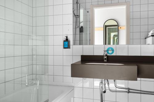 a bathroom with a sink and a mirror at Comfort Hotel Børsparken in Oslo