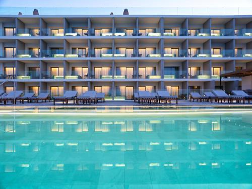 einen Blick nach außen auf ein Hotel mit Pool in der Unterkunft NIKO Seaside Resort MGallery in Agios Nikolaos