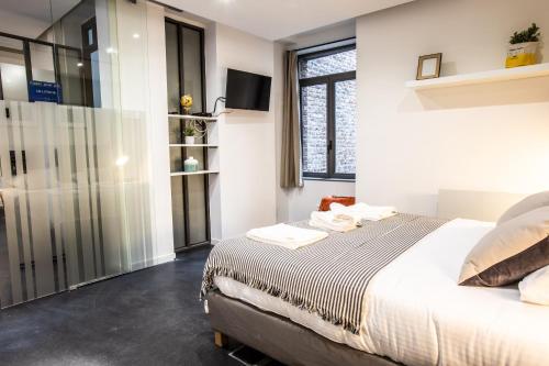 a bedroom with a bed and a sliding glass door at Flandres Appart' Hotel - Schepers in Lille