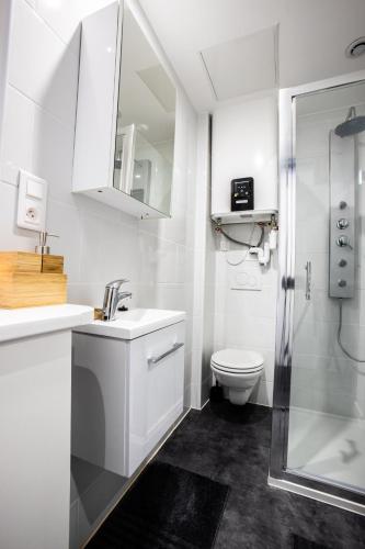 a white bathroom with a sink and a toilet at Flandres Appart' Hotel - Schepers in Lille