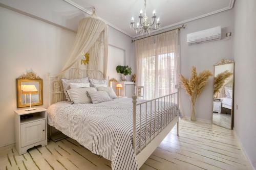 a bedroom with a white bed and a chandelier at Luxury Apartment Zeas Piraeus in Piraeus