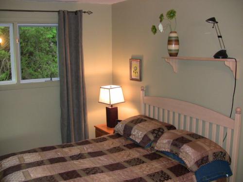 a bedroom with a bed and a window at La Source Enchantée in Baie-Saint-Paul