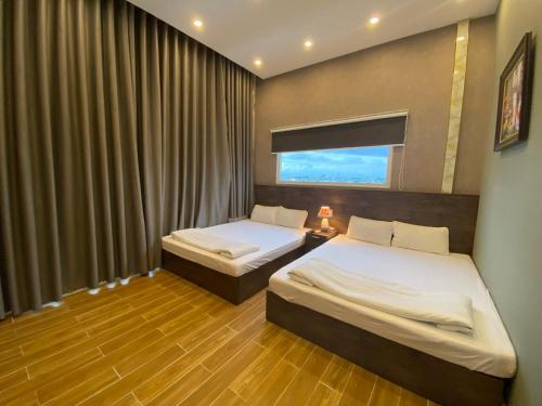 a hotel room with two beds and a window at CONVOI HOTEL in Can Tho