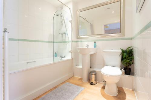 uma casa de banho com um WC, uma banheira e um lavatório. em Modern Spacious studio close to station em Londres