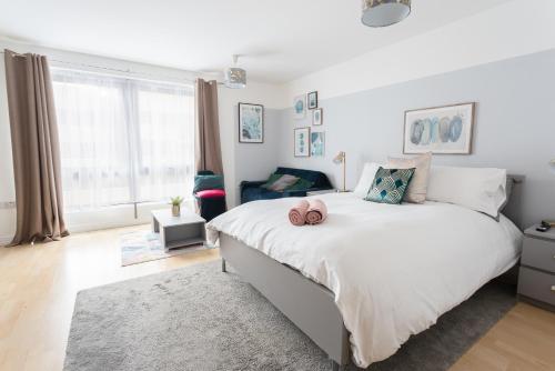 a bedroom with a large bed with a large window at Modern Spacious studio close to station in London