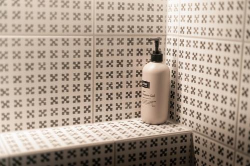 a bottle of soap is sitting on a shelf in a bathroom at Hotel Siglunes in Siglufjörður