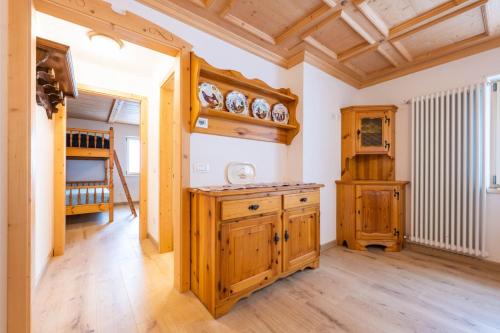 a kitchen with wooden cabinets and a wooden ceiling at Bilocale Fiore in Campitello di Fassa