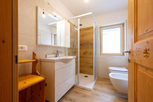 a bathroom with a sink and a toilet and a shower at Bilocale Fiore in Campitello di Fassa