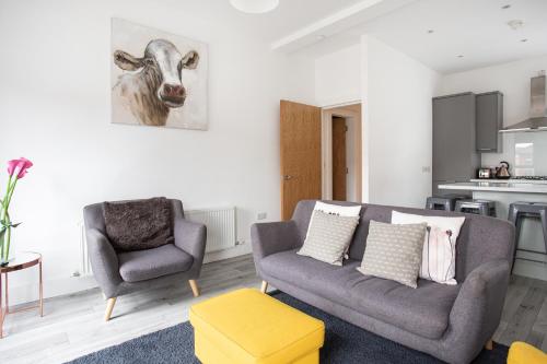 ein Wohnzimmer mit einem Sofa und einem Stuhl in der Unterkunft Modern Luxury Apartment, Sleeps 6, Best Location in Belfast