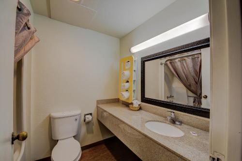 La salle de bains est pourvue de toilettes, d'un lavabo et d'un miroir. dans l'établissement Motel 6-San Antonio, TX - Medical Center South, à San Antonio