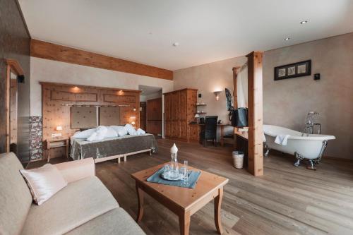 a living room with a bed and a bath tub at Wellness Aparthotel Panorama Alpin - Ferienwohnungen Jerzens im Pitztal in Jerzens