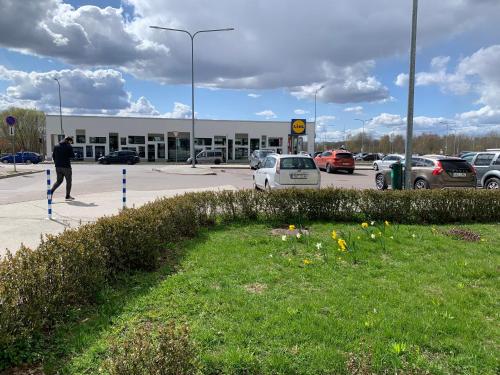 a man walking in front of a parking lot at K84, Nice 2- bedroom apartment - 2 big beds 1 single bed in Tartu