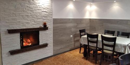 a dining room with a table and a fireplace at Къща за гости Релакс-Рaдуил in Raduil
