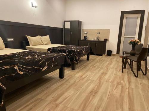 Habitación de hotel con 2 camas y suelo de madera. en RR Holidays - Home Stay en Kodaikānāl