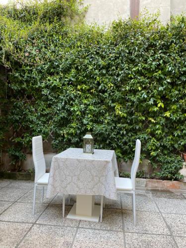 a table with two chairs and a clock on it at Hotel Apostoli Garden in Venice
