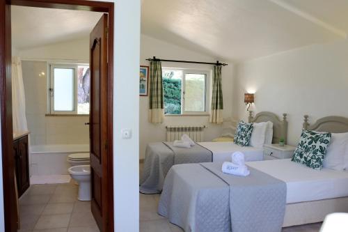 una camera con due letti e un bagno di Villa Laranjal a Mexilhoeira Grande