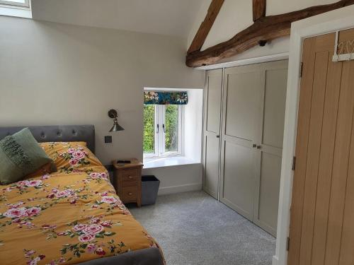 a bedroom with a bed and a window at The Stables at Cotton (one mile from Alton Towers) in Oakamoor