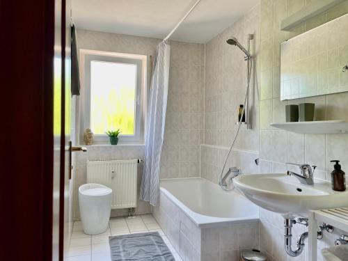 a bathroom with a white tub and a sink at LaMiaCasa Balcony Near Bosch and Train Station in Renningen