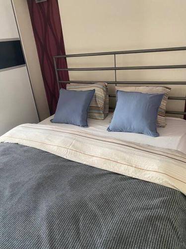 łóżko z dwoma niebieskimi poduszkami na górze w obiekcie Panama Apartament 3 Poznań w Poznaniu