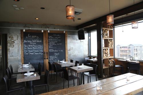 a dining room with tables and chairs and a chalkboard at Adrift Hotel in Long Beach