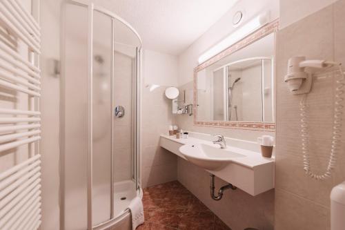 a white bathroom with a sink and a shower at Wellness Aparthotel Panorama Alpin - Ferienwohnungen Jerzens im Pitztal in Jerzens