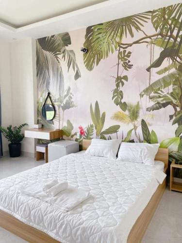 a bedroom with a large bed with plants on the wall at HOSTEL ARIA in Quy Nhon