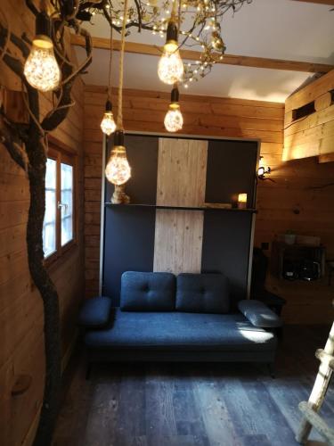 - un canapé bleu dans une chambre avec un arbre dans l'établissement Sortilège, à Lambesc
