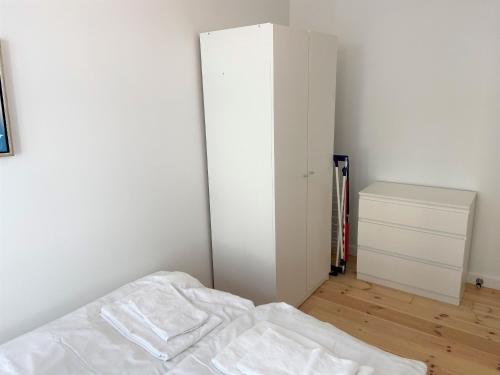 Dormitorio blanco con cama y armario en Cozy apartment in elegant Østerbro, en Copenhague