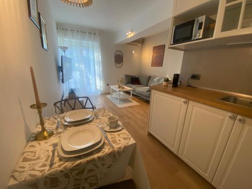 a kitchen and living room with a table with plates on it at Apartments Fantasia in Pula