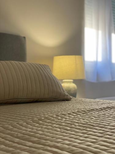 a bed with a pillow and a lamp in a bedroom at Apartments Fantasia in Pula