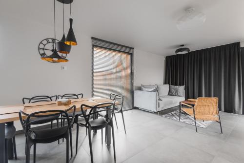 jadalnia ze stołem, krzesłami i kanapą w obiekcie Mazurski Dom nad Jeziorem & Sauna by Downtown Apartments w mieście Tomaszkowo