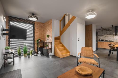salon ze schodami, stołem i krzesłami w obiekcie Mazurski Dom nad Jeziorem & Sauna by Downtown Apartments w mieście Tomaszkowo