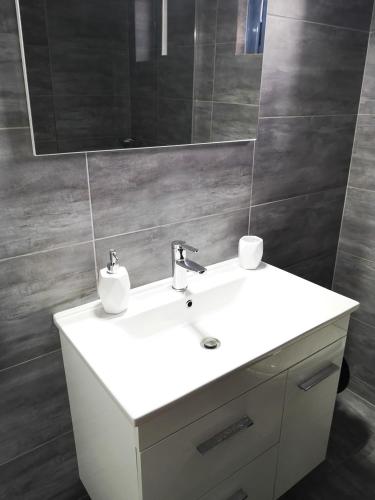 a bathroom with a white sink and a mirror at Archos Seafront Apartments in Porto Heli