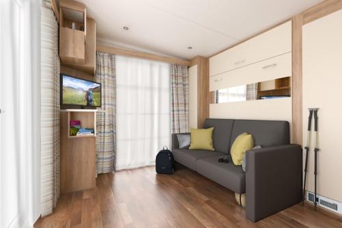 a living room with a couch and a television at Higher Moor Farm in Weymouth