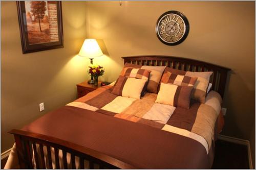 - une chambre avec un lit et une lampe sur un mur dans l'établissement Eagle's Den Suites Cotulla a Travelodge by Wyndham, à Cotulla