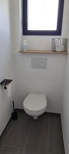 une salle de bain avec des toilettes blanches et une fenêtre dans l'établissement Guest house, très calme, piscine, à Perrouse