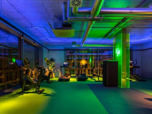 a room with a gym with green and blue lights at b'mine Hotel Frankfurt Airport in Frankfurt/Main