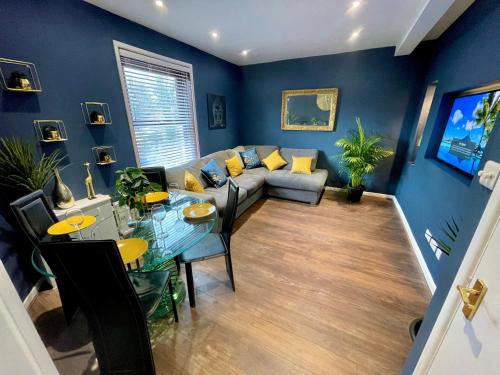 a living room with a couch and a table at Cozy Two Bedroom - A Stroll from Gardens to Beach - With Parking in Bournemouth