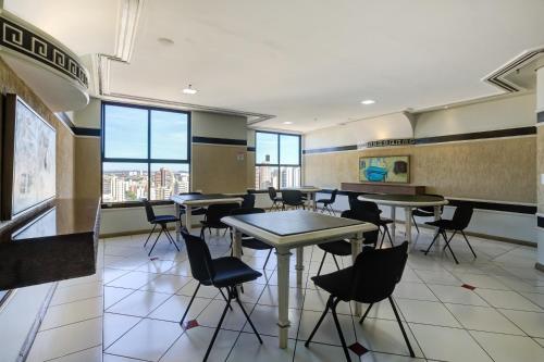 a classroom with tables and chairs in a building at Slaviero Londrina Flat in Londrina