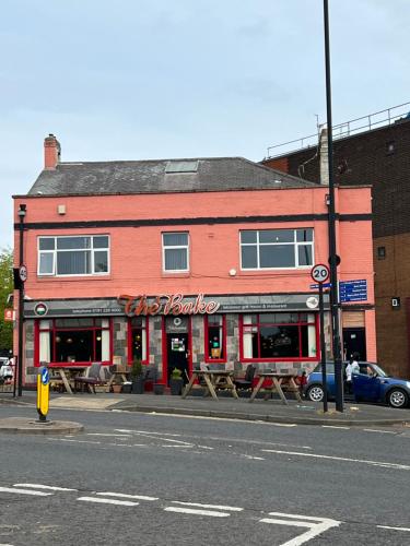 a red building with tables in front of it on a street at The Bake Apartment - 5 bedroom Large Apartment sleeps up to 16 person in Newcastle upon Tyne