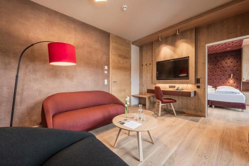 a living room with a couch and a bed at Hotel Kristall - Adults only in Leutasch