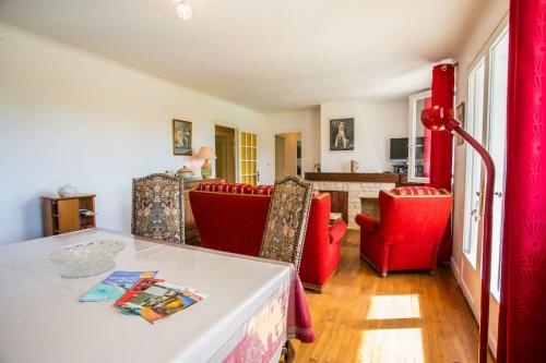 un salon avec des chaises rouges et une table dans l'établissement CHEZ MICHEL ET FABIENNE, à Sarlat-la-Canéda